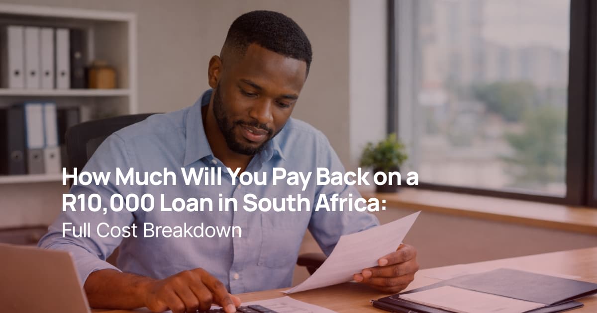African man calculating loan repayment using calculator and documents in an office