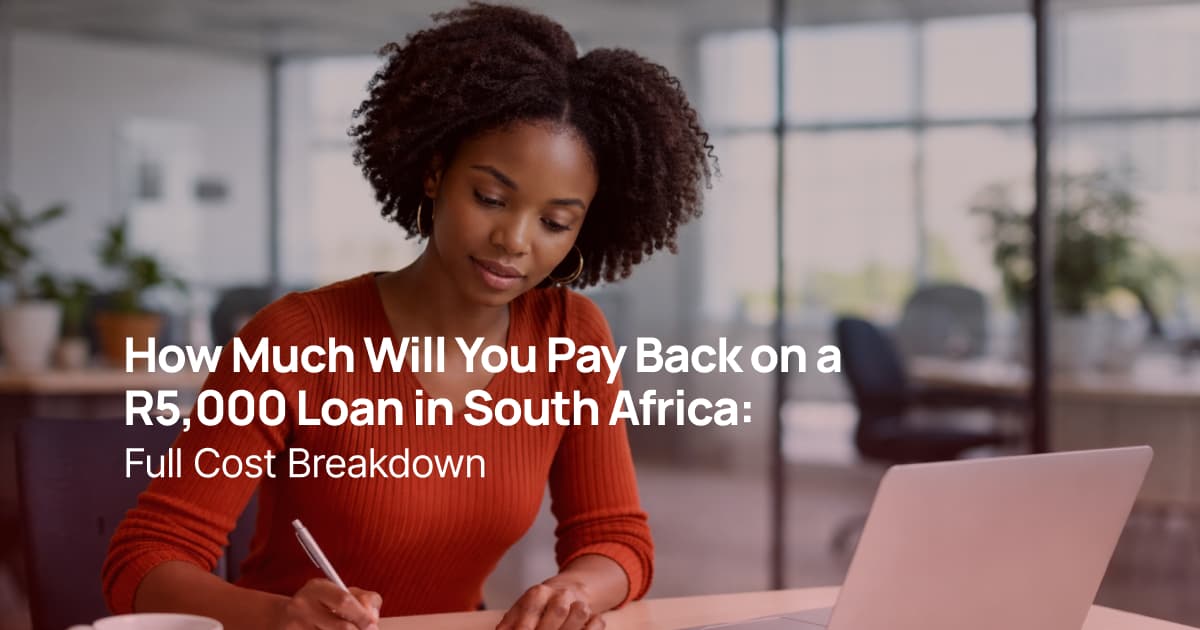 African woman calculating loan repayment using a laptop and calculator in an office environment
