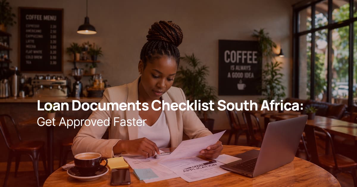 African woman reviewing and preparing loan application documents while sitting in a coffee shop with a laptop and paperwork