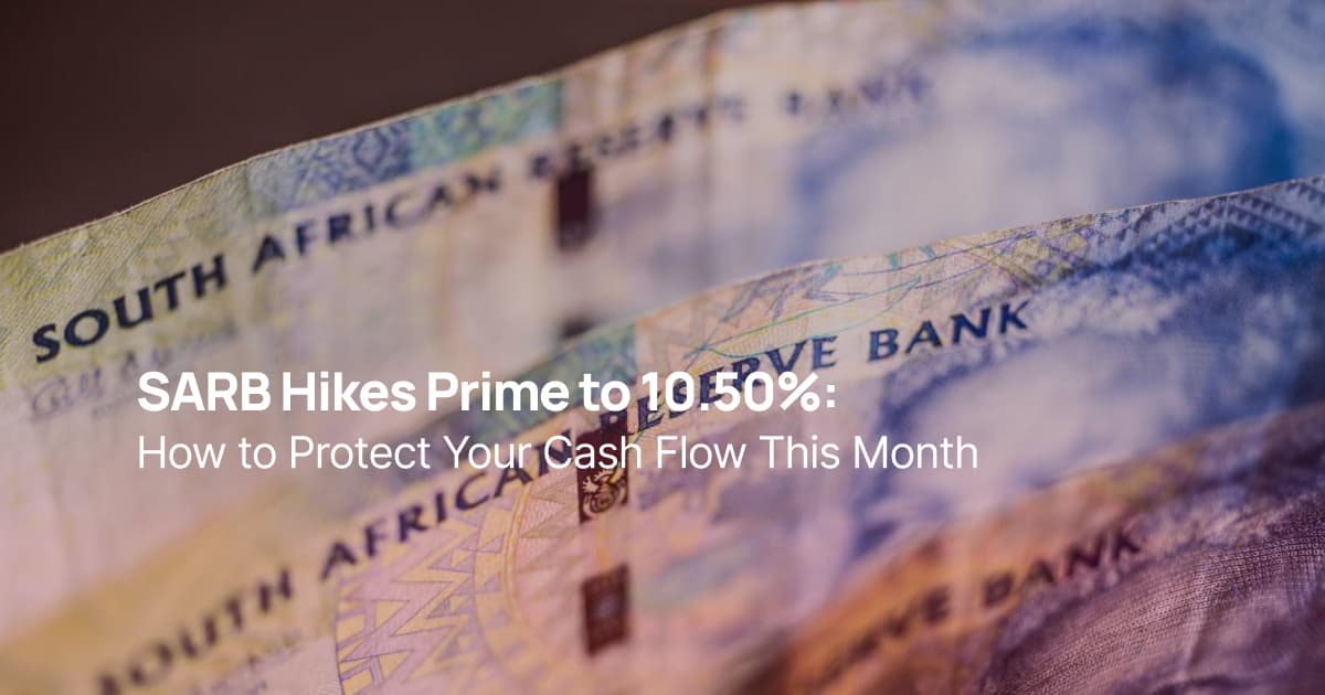 South African rand banknotes with a blurred South African flag in the background, representing interest rates, inflation, and monetary policy.