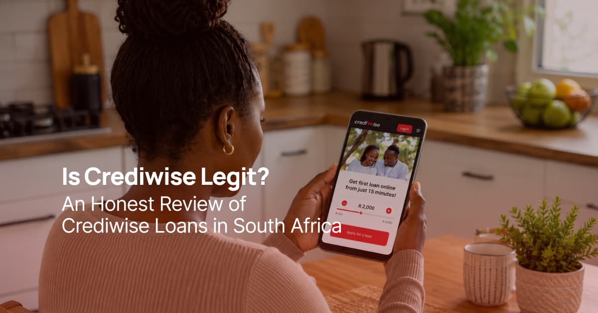 South African woman using her smartphone in her kitchen to apply for a Crediwise loan online.